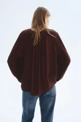 Blusa oversized de viscosa color marrón, con escote en V pronunciado, cordón para ajustar con cuentas en los extremos, frunces en los hombros, mangas globo largas con elástico en los puños y canesú fruncido en la espalda.