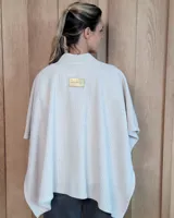 Ruana abierta de tejido de punto acanalado en color beige, con diseño holgado y caída fluida.