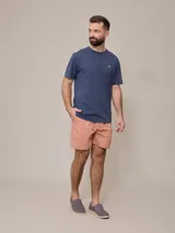 Short de baño azul marino con cintura elástica ajustable con cordón y logo de la marca bordado en rojo en la pierna izquierda.