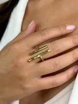 Anillo de diseño geométrico elaborado en latón, compuesto por dos barras horizontales paralelas con acabado texturizado y pulido.