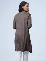 Chaqueta larga color marrón, marca Philosophy, confeccionada en símil suede. Tiene cuello con solapa, abertura central y cintura trasera con jareta interna de ajuste. El largo de las mangas es regulable con presilla y botón.