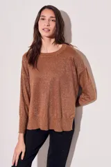 Sweater color cobre con lurex, de corte holgado y mangas largas.