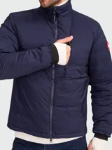 Campera acolchada azul marino marca Canada Goose, modelo Lodge, con cierre frontal, cuello alto y logo en el brazo.