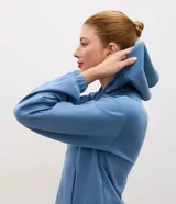 Campera deportiva de modal negro con capucha, cierre frontal por cremallera, cordones ajustables, bolsillos y mangas largas con puños elásticos.
