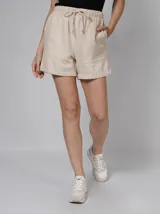 Short color beige de gaza doble con cintura elástica ajustable con cordón, bolsillos laterales y trasero, y corte holgado.