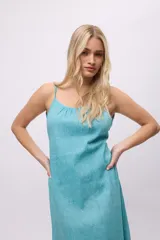 Vestido largo color celeste, de tirantes finos y espalda descubierta. Presenta volados en el ruedo y escote fruncido.