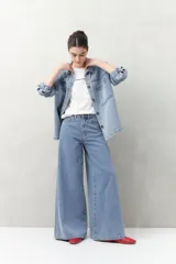 Jean de tiro alto, color celeste claro, con calce ultra wide leg y silueta amplia desde la cadera hasta el bajo. Presenta diseño clásico de cinco bolsillos y cierre con botón metálico y cremallera.