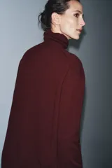 Jersey de corte oversize confeccionado en lana 100%, con cuello subido y manga larga.