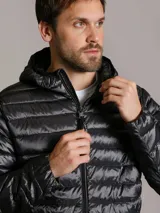 Campera acolchada Calvin Klein con capucha, cierre frontal con cremallera y bolsillos laterales con cierre. Presenta un diseño ligero y funcional con acabado brillante.