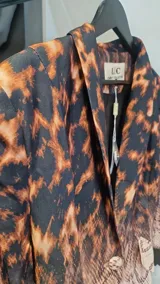 Blazer entallado con hombreras, con un diseño que combina estampado de leopardo en la parte superior y degradado de piel de serpiente en la inferior.