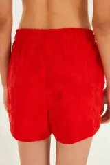 Shorts rojos con textura y cintura elástica.