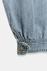 Jeans negro de tiro medio con corte balloon fit, diseño de cinco bolsillos y bajo acabado en puño con abertura y botón.