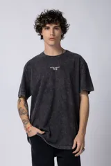 Remera de algodón con efecto lavado ácido en color gris oscuro, de corte holgado y cuello redondo. Presenta un pequeño estampado gráfico en el centro del pecho con la inscripción Astral Energy.