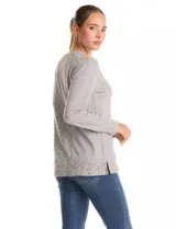 Buzo de manga larga con cuello a la base, confeccionado en tejidos combinados con texturas lisas y acanaladas. Presenta un diseño con tajos laterales en el ruedo.