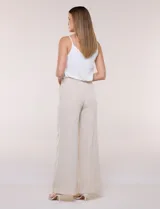 Pantalón de vestir de tiro alto, color beige, con corte wide leg y pinzas frontales.