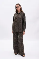 Pantalón ancho de tiro medio con cordón ajustable en la cintura y estampado de patrón orgánico en tonos marrón y negro.