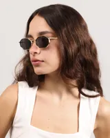 Lentes de sol con marco dorado y forma ovalada.