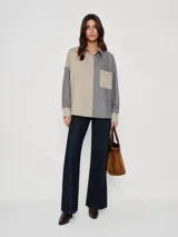 Camisa oversize de diseño bicolor, confeccionada en casimir de lana liviano. Presenta un lado en color beige liso y el otro en gris con rayas verticales finas, bolsillo frontal, cartera con botones y puños en contraste.