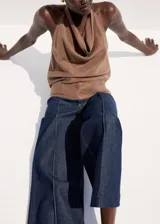 Pantalón de jean azul oscuro con corte recto y tiro medio. Presenta costuras verticales marcadas en el frente de cada pierna y diseño de pierna ancha.