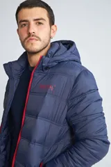 Campera puffer Mistral de hombre, color azul marino con cierre frontal y detalles en color rojo. Cuenta con capucha, puños elásticos y logo estampado en el pecho.