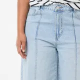 Jean de corte wide leg en color azul claro, con talle alto y detalle de pinzas verticales en la parte frontal. Presenta un diseño de pierna ancha y cierre clásico con botón y cremallera.