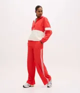 Pantalón deportivo Get Over de color rojo con cintura elástica, bolsillos laterales y doble franja blanca en los laterales.