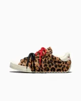 Championes Converse Chuck Taylor Low con exterior de pelo con estampado animal print de leopardo, puntera de goma blanca, y doble juego de cordones en color rojo jaspeado y negro.
