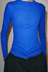 Camiseta de algodón negro de corte slim fit, con cuello subido, manga larga y cierre frontal de botones pequeños.