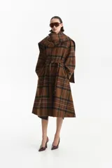 Abrigo largo tipo trench con estampado a cuadros en tonos marrones. Presenta un cuello que simula una bufanda integrada, cierre mediante lazo ajustable en la cintura y mangas largas. Confeccionado en una mezcla de lana y poliéster con forro interior.