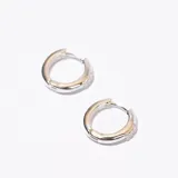 Aros tipo argolla plateados con pequeños brillantes incrustados.