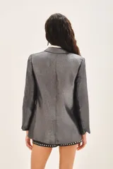 Saco de corte sastre con acabado metalizado, de calce recto y estructura clásica con solapas.