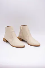 Botín de cuero dorado con punta fina y taco bajo cuadrado de madera.