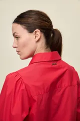Camisa de algodón blanca con cuello camisero, frente abotonado y mangas abullonadas de corte relajado.