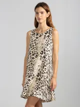 Vestido corto sin mangas, con corte en A, escote redondo y bajo redondeado con dobladillo asimétrico. Presenta un diseño estampado que combina motivos de animal print de leopardo y cebra.