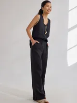 Pantalon de corte recto y tiro medio, confeccionado en lino, con cintura elastizada y tajos laterales en el ruedo.