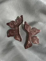 Par de aros con forma de media flor en tono bronce, con detalles de strass y gancho de acero quirúrgico.