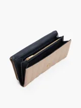 Billetera Tommy Hilfiger de poliuretano color beige, con diseño acolchado, cierre de solapa y logo metálico dorado TH en el frente.