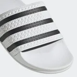 Sandalias Adidas Adilette de color blanco con tres tiras negras en la banda superior y plantilla contorneada.