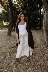 Cinturón artesanal de cuero color arena, con flecos largos y hebilla cuadrada metálica.