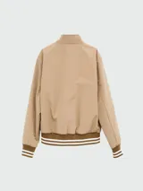 Campera cazadora reversible Moncler, con diseño acolchado en color bordó de un lado y color beige del otro. Presenta cuello tipo bomber con franjas, cierre frontal con cremallera y puños elásticos a rayas.