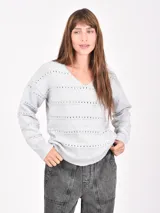 Buzo de tejido de punto gris claro, con cuello en V y detalles de perforaciones horizontales a lo largo del frente y mangas.