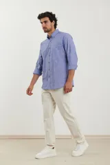 Camisa de manga larga color gris claro con textura, cuello abotonado y bolsillo en el pecho.