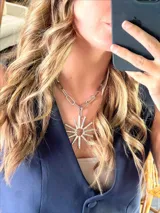 Collar plateado con cadena de eslabones grandes y dije con forma de sol.