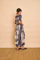 Vestido midi amarillo y blanco con estampado de paisajes y detalles de rayas en el cuello y el dobladillo, de corte holgado, mangas cortas y lazo ajustable en la cintura.
