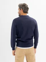 Buzo tejido de punto color azul marino, con cuello polo y cierre frontal parcial en el escote, de manga larga y puños y cintura acanalados.