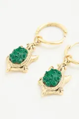 Aro colgante dorado con forma de tortuga y una piedra de resina verde en el centro.