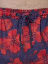 Short de baño con estampado botánico en tonos naranja y coral, con cintura elástica ajustable mediante cordón y malla interior para mayor soporte.