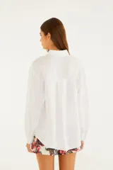 Camisa de lino color blanco, de corte levemente holgado, cuello clásico y mangas largas con puños abotonados.