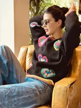 Sweater tejido artesanalmente en lana color negro, con apliques de corazones hechos a mano en crochet.