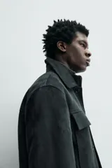 Sobrecamisa regular fit color verde oscuro, confeccionada en tejido efecto ante. Cuenta con cuello solapa, manga larga con puño abotonado, bolsillos de plastrón con solapa en el pecho y bolsillos de vivo en la cadera. El cierre es frontal con botonadura.